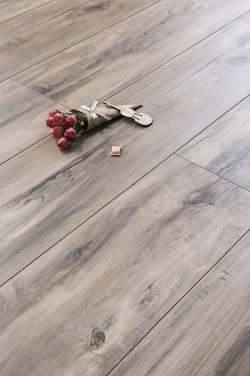 A bunch of keys are laying on a wooden floor.