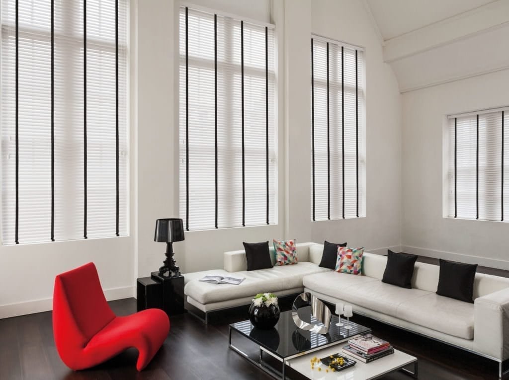 A living room with a white couch and a red chair