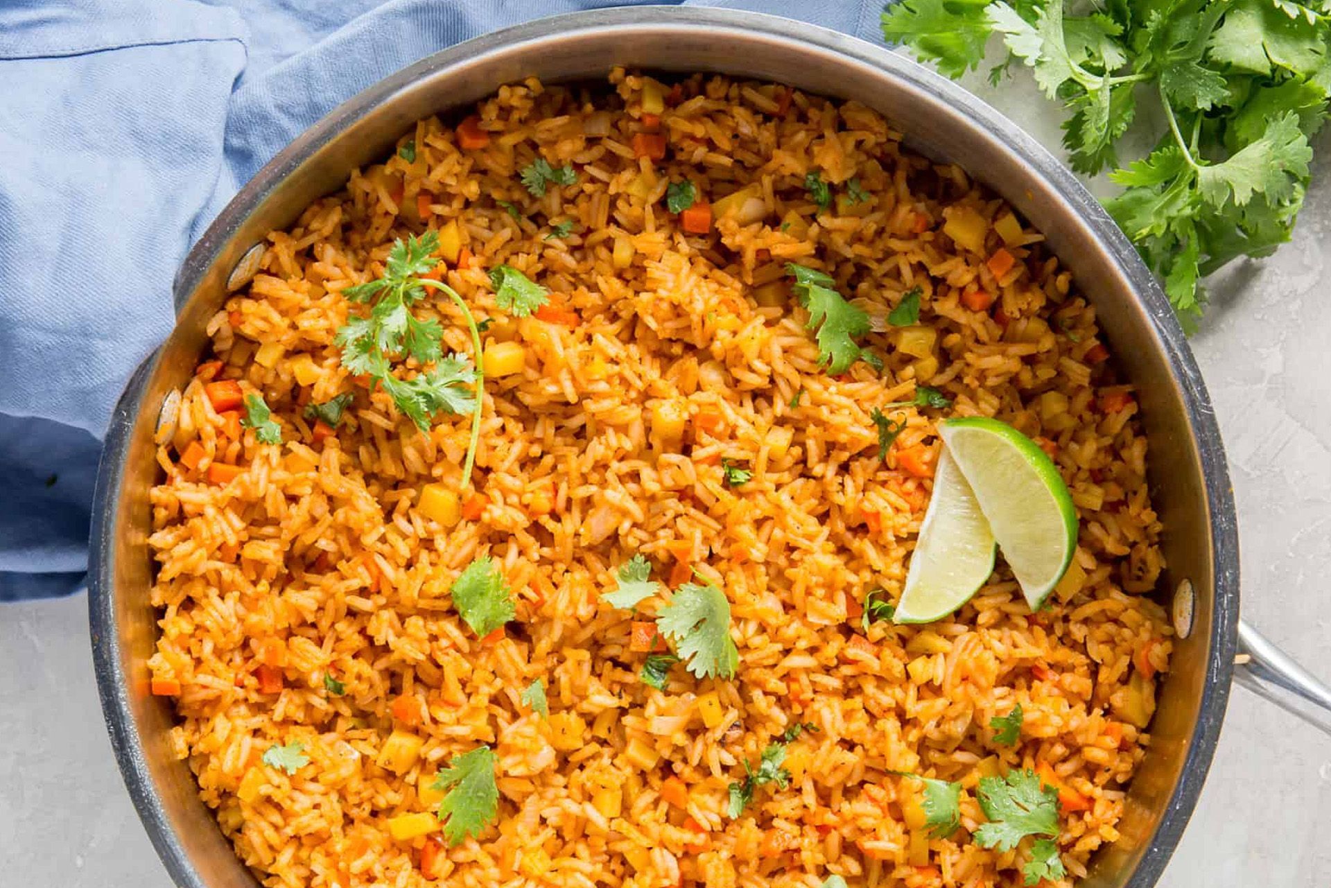 Pasta with red sauce, garnished with basil and a red chili pepper, on a white plate.
