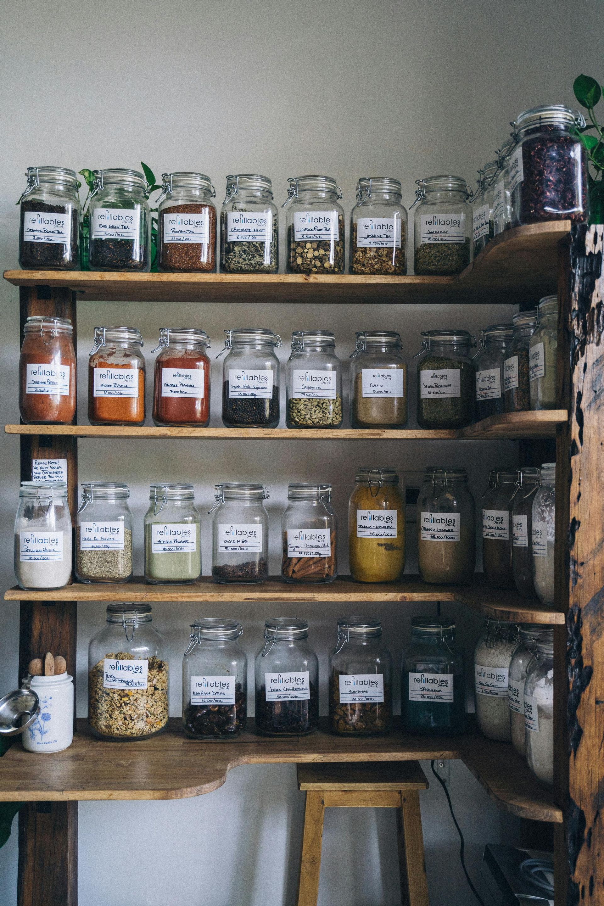 Spice jars on wooden shelves. Labels on jars indicate contents.