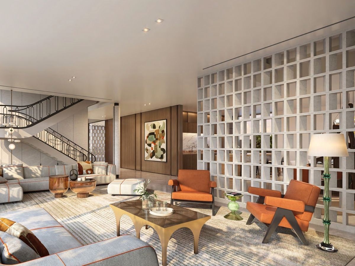 Modern living room with orange armchairs, geometric wall, and staircase.