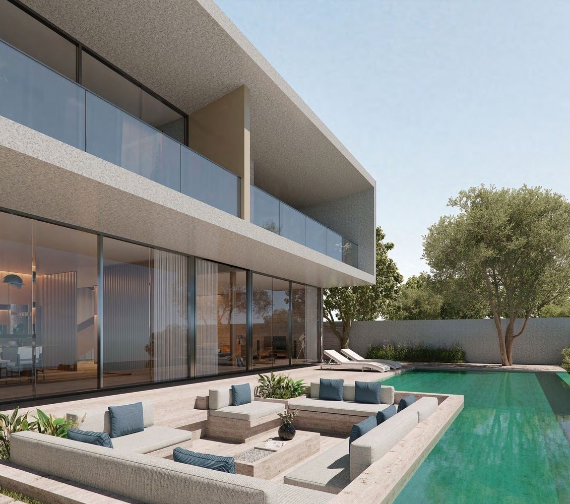 Modern house with pool, outdoor seating area, glass walls, and clear sky.