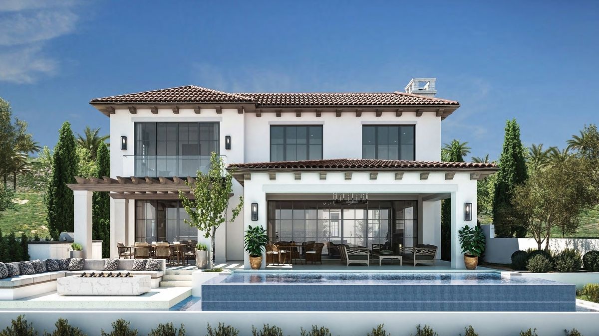 Two-story Spanish-style house with pool. White exterior, brown roof tiles, and outdoor seating area.