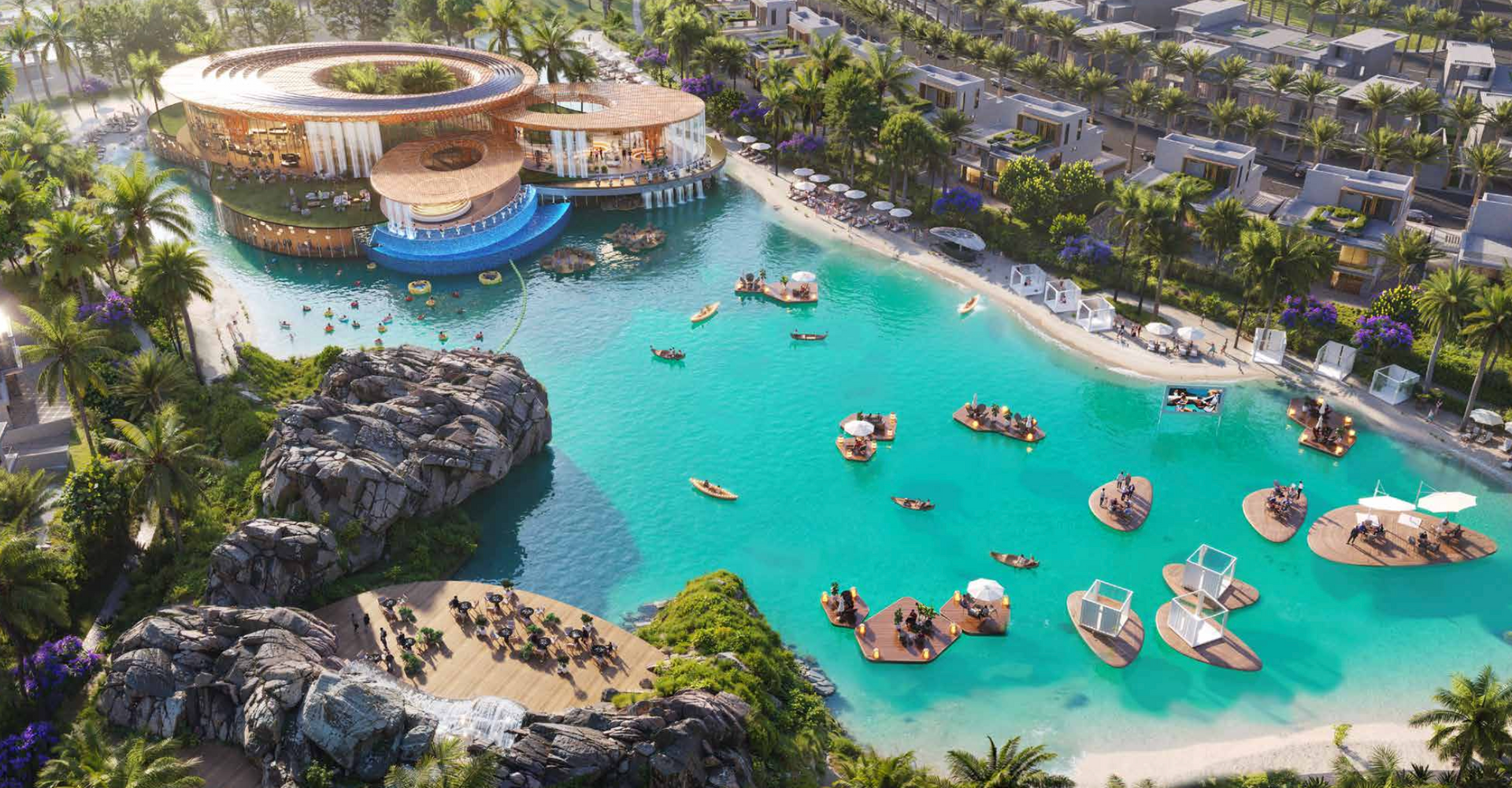 Aerial view of a lagoon with people swimming and boating, surrounded by buildings and landscaping.