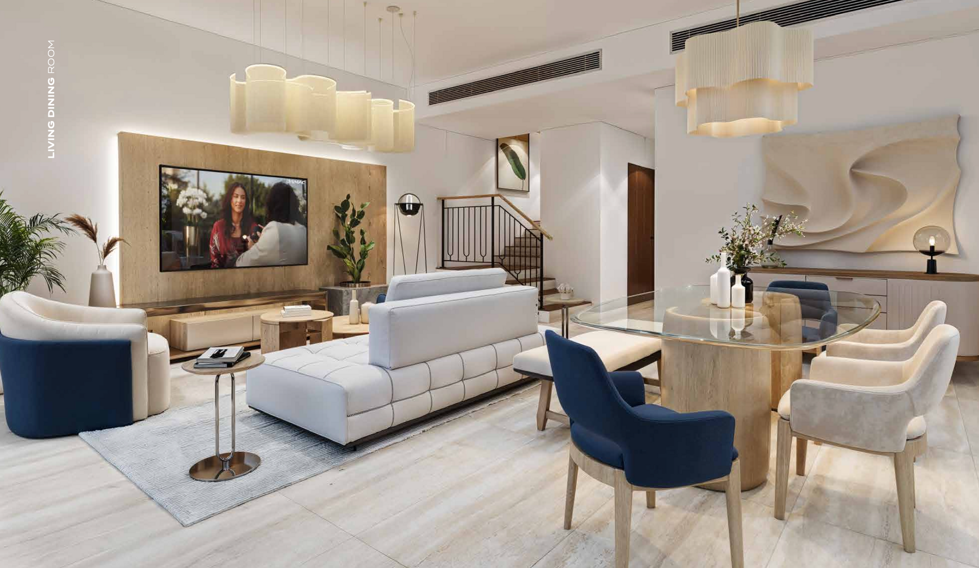 Elegant living room with white and blue furniture, a staircase, and modern art.