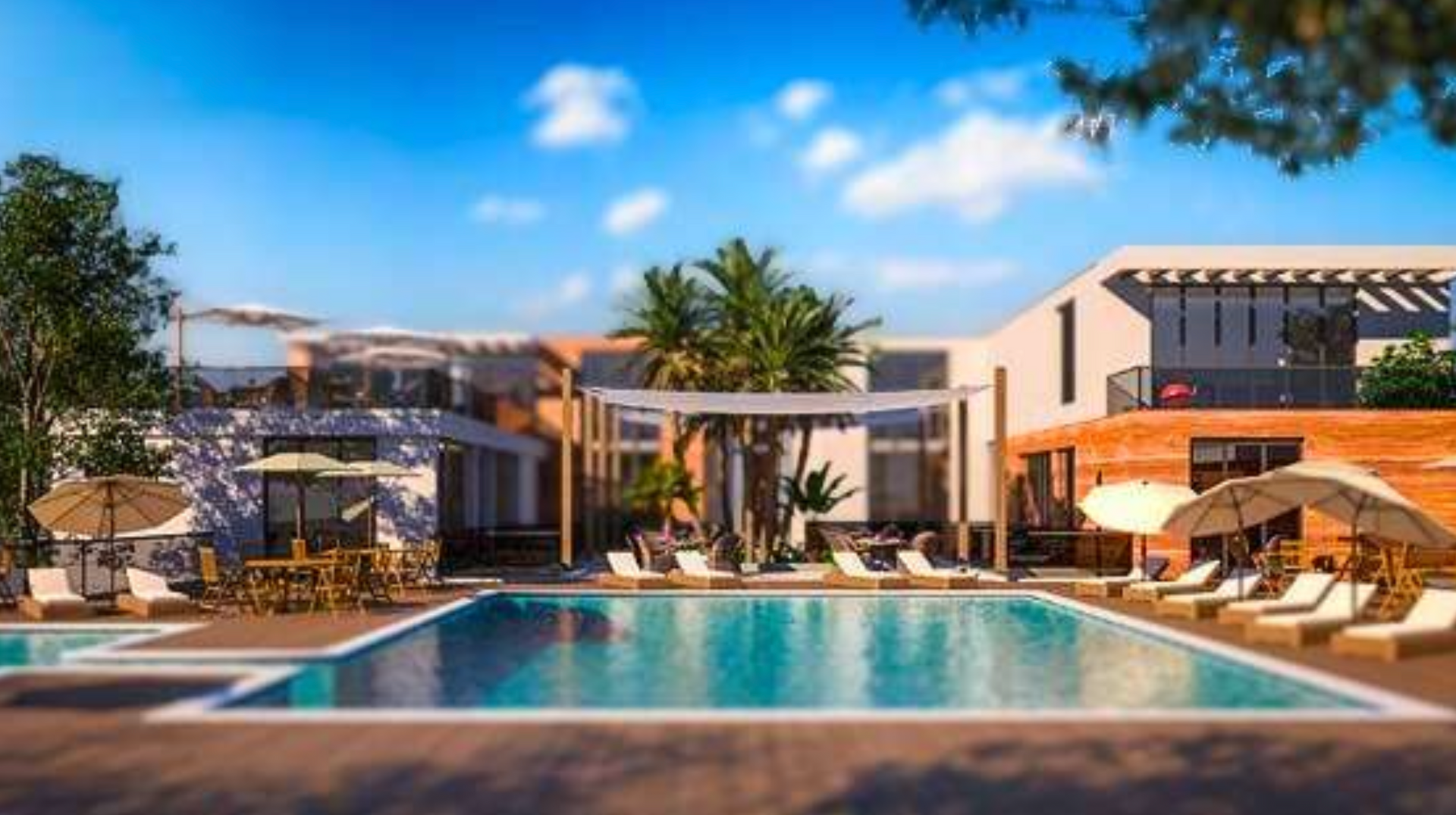 Pool area with lounge chairs, umbrellas, and tables at a resort under a blue sky.