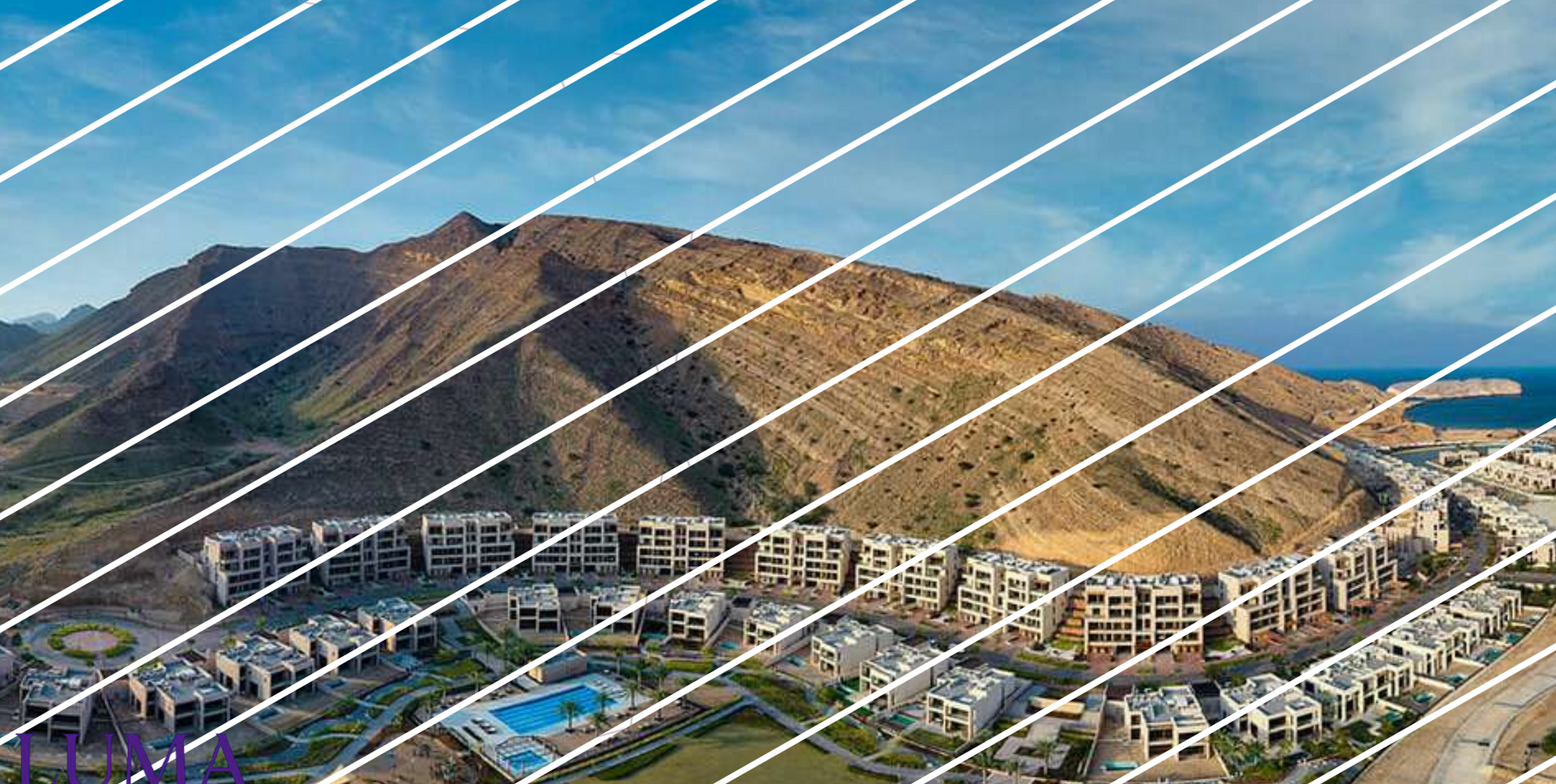View of a mountain and a residential area with a blue sky, partially obscured by white diagonal lines.