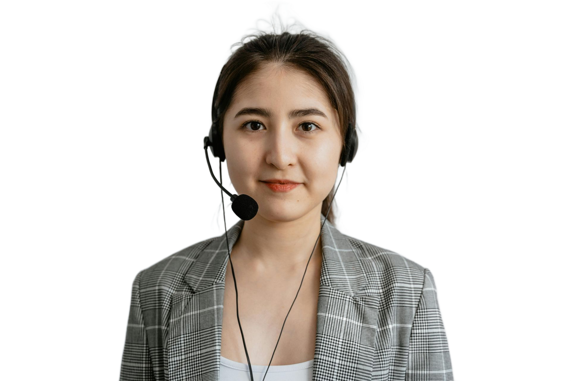 Woman wearing a headset, in a plaid blazer, looking directly at the viewer, on a white background.