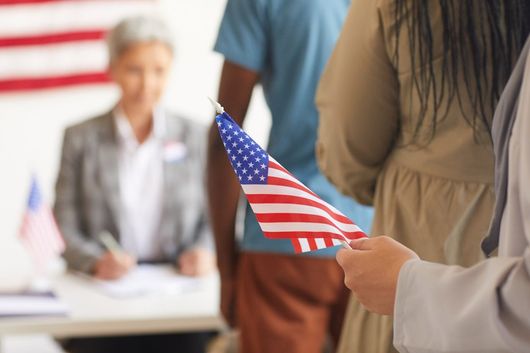 line at office with someone holding american flag