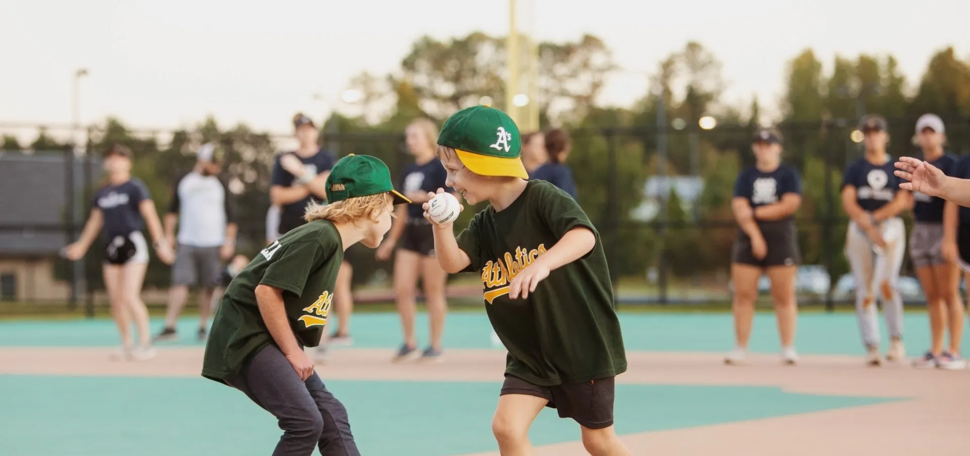 Two young boys are playing baseball on a field.