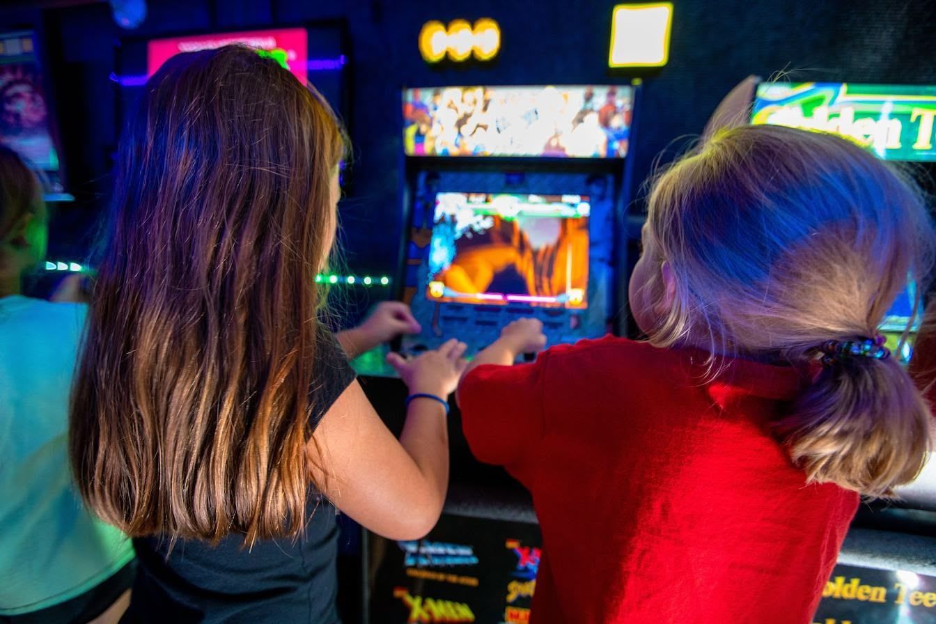 Two young girls are posing for a picture at a playground.