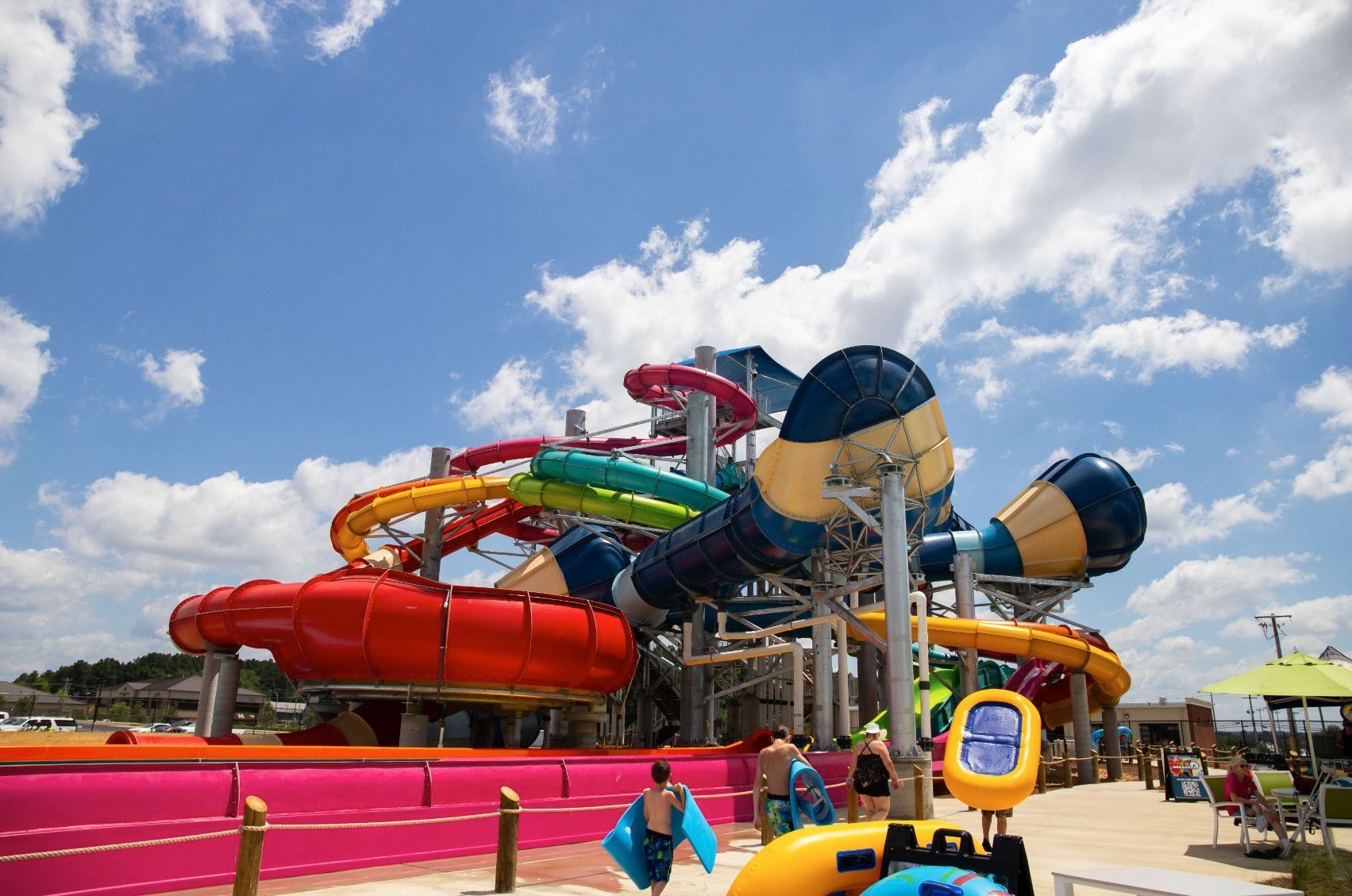 A water park with a lot of water slides and a clock.