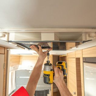 a person is using a drill to install a ceiling fan in a camper
