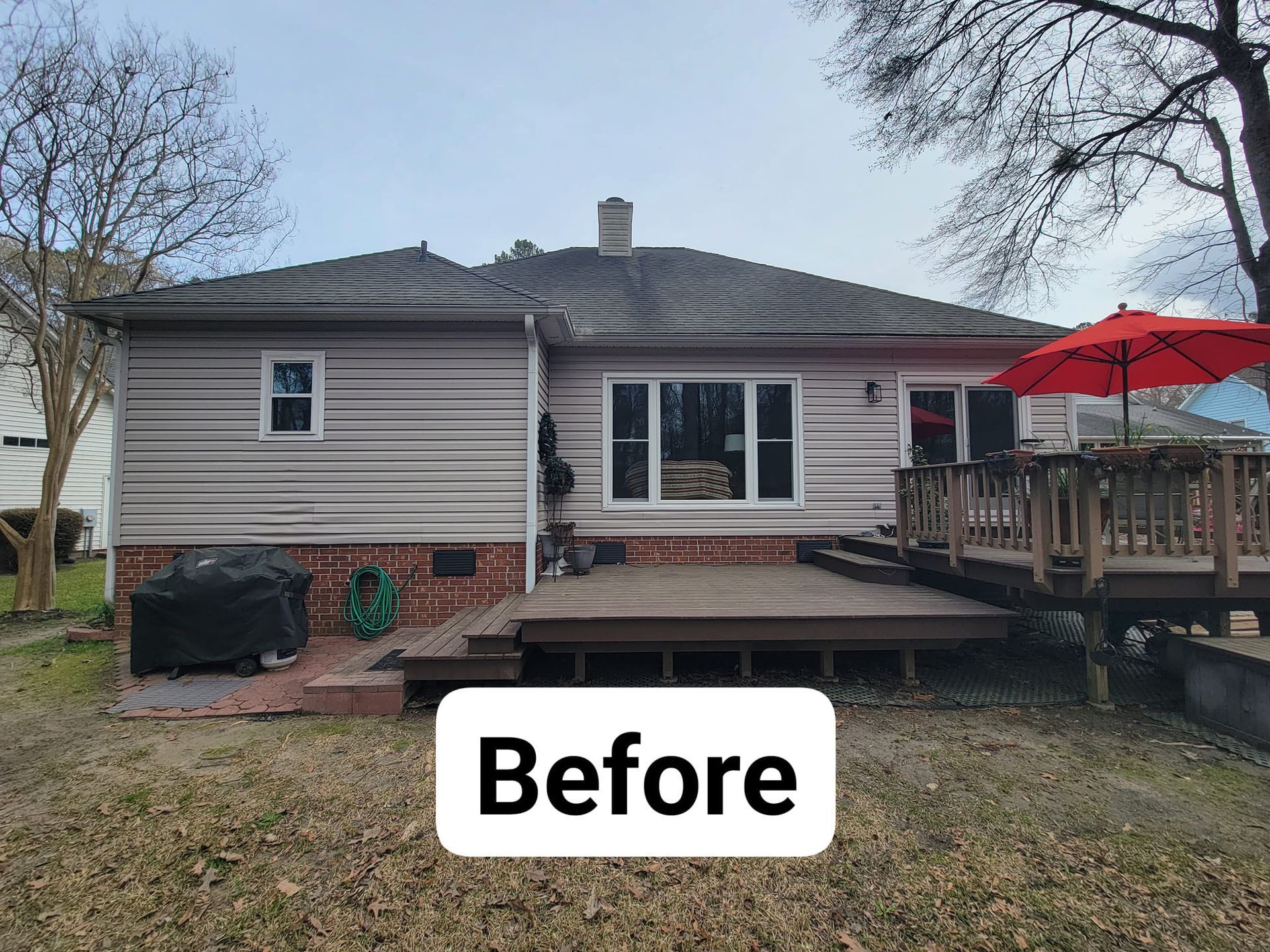 A before picture of a house with a deck and umbrella.