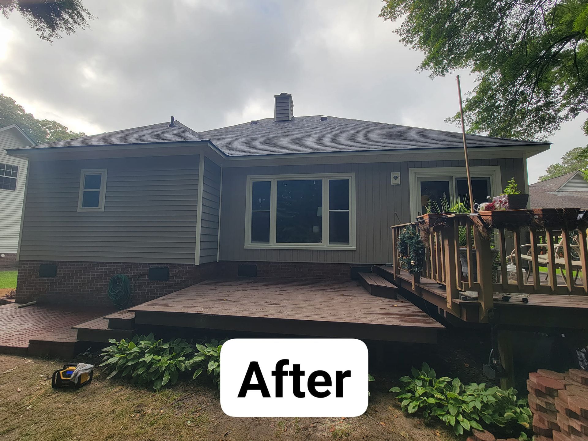 The back of a house with a deck and a sign that says `` after ''.