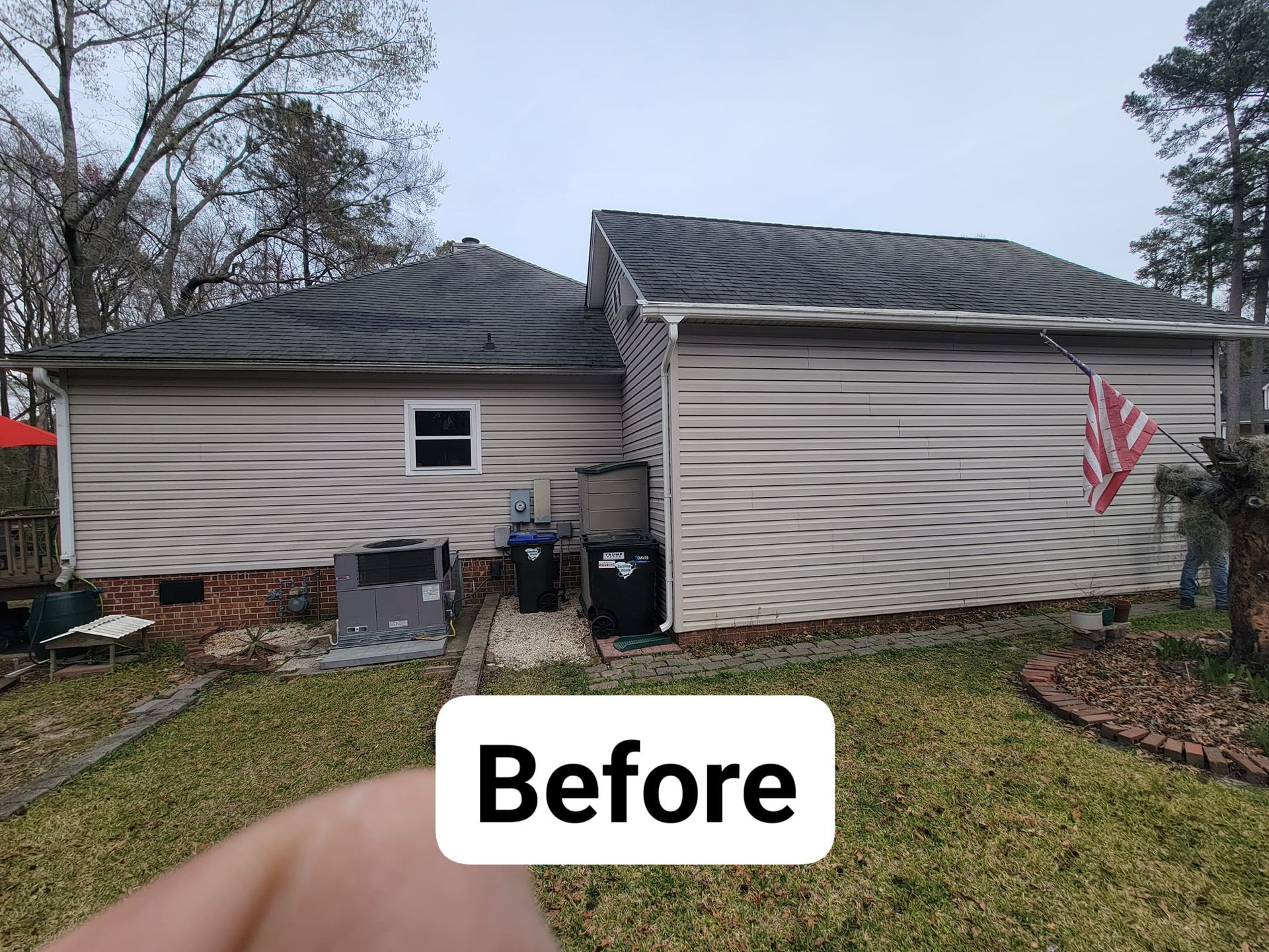 A before picture of a house with a flag on the side.