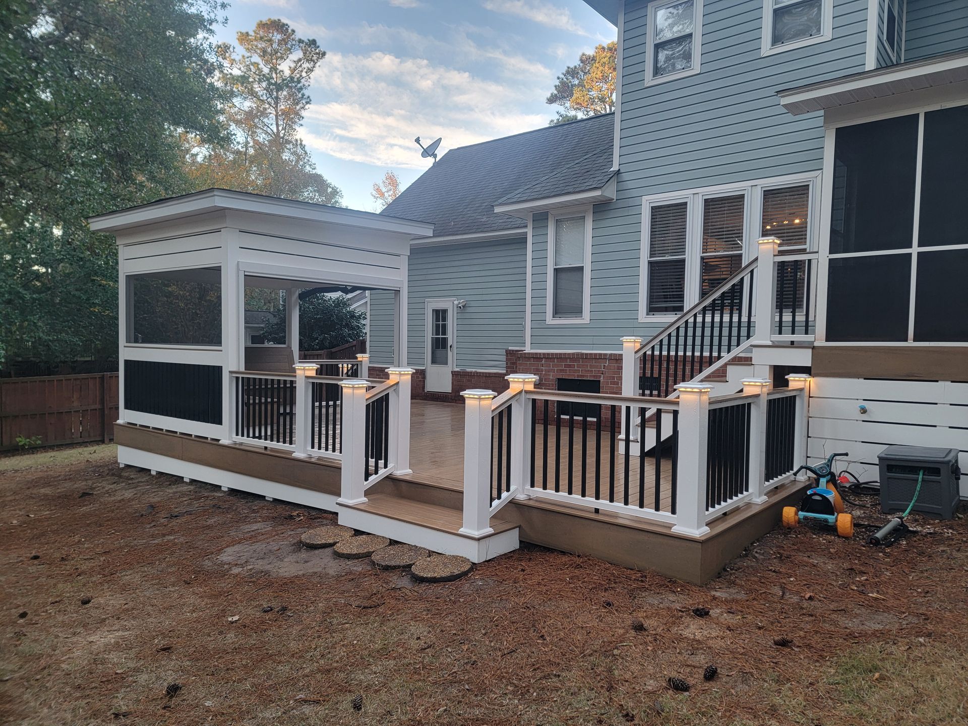 A house with a screened in porch and stairs.