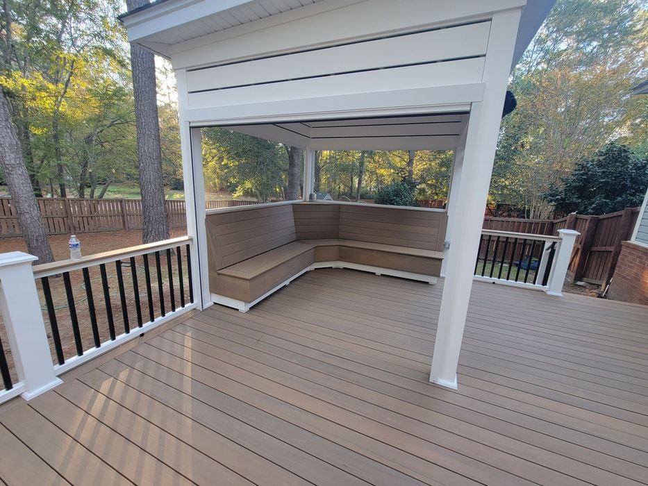 A deck with a gazebo and a couch on it.