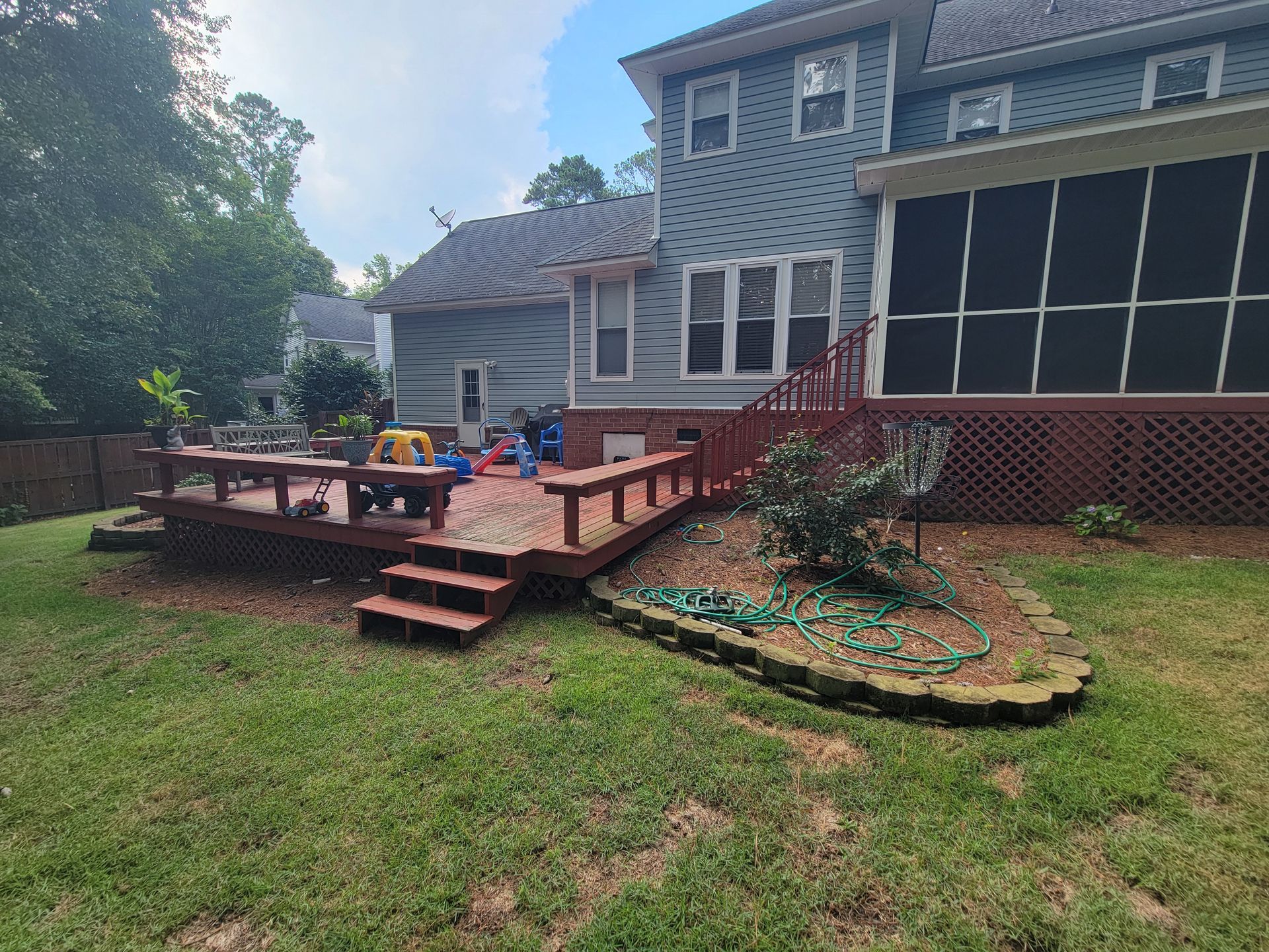 A large house with a screened in porch and a wooden deck.