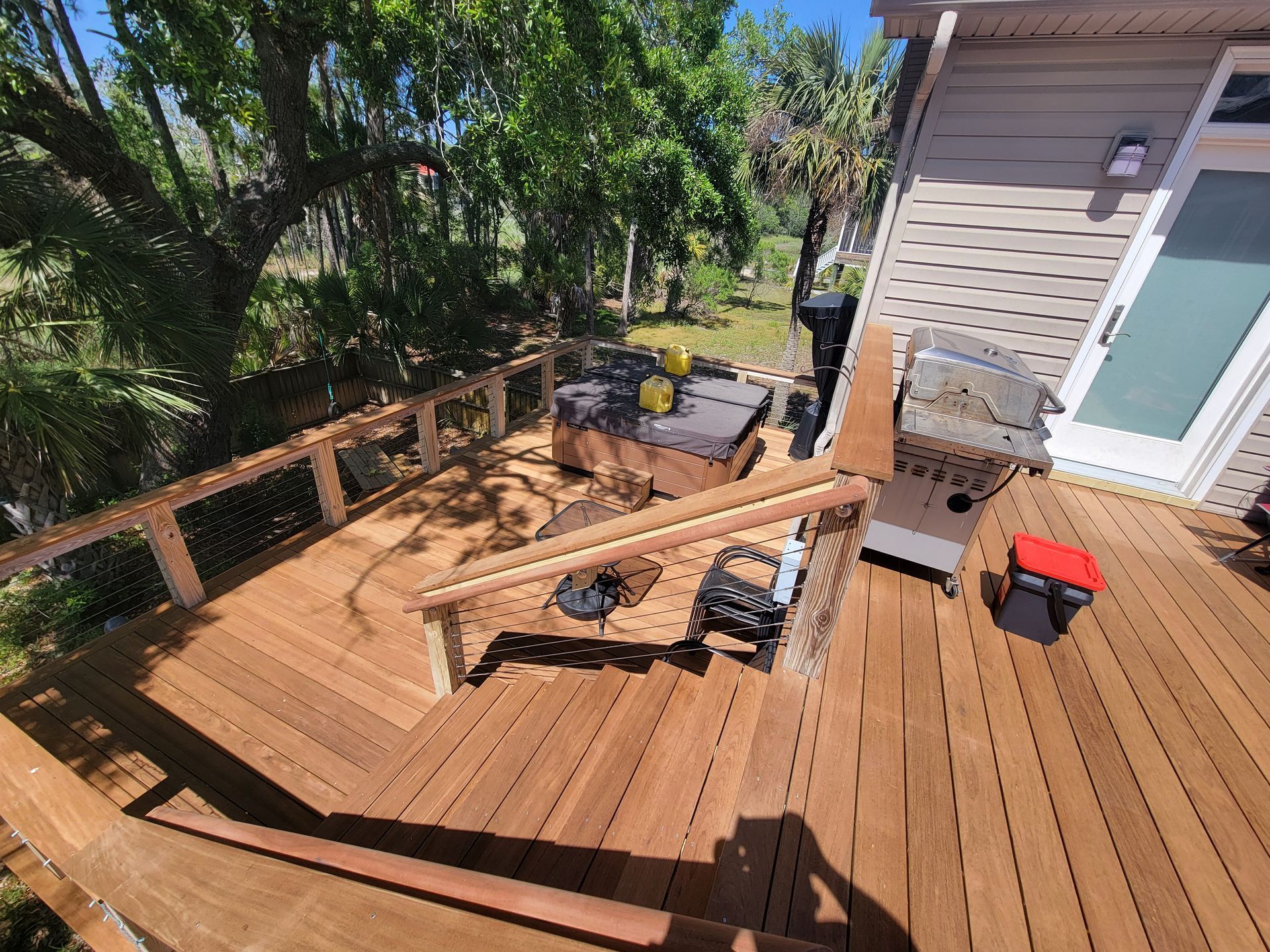 A wooden deck with stairs leading up to a house.
