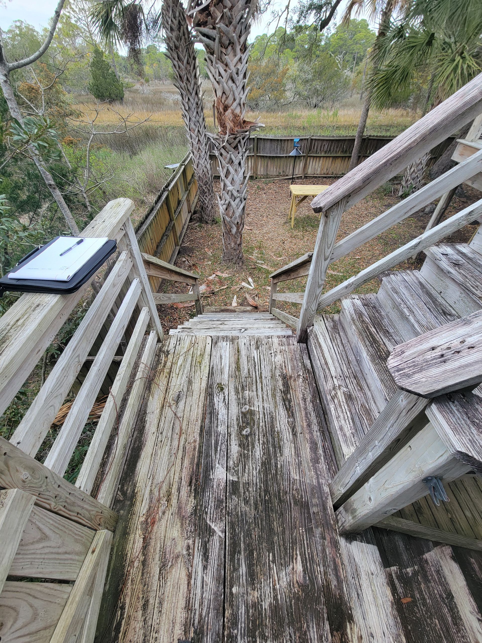A wooden bench is sitting next to a set of stairs.