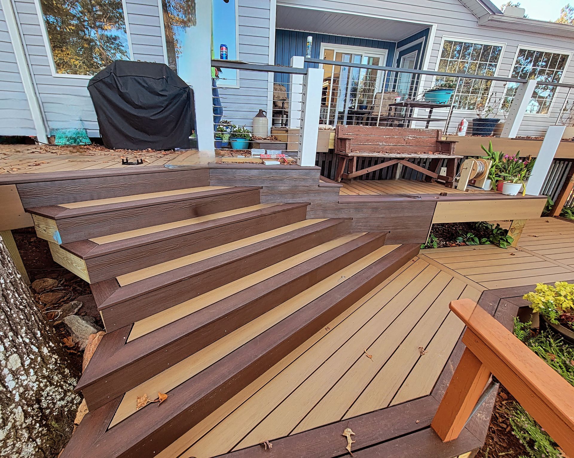 A wooden deck with stairs leading up to a house.