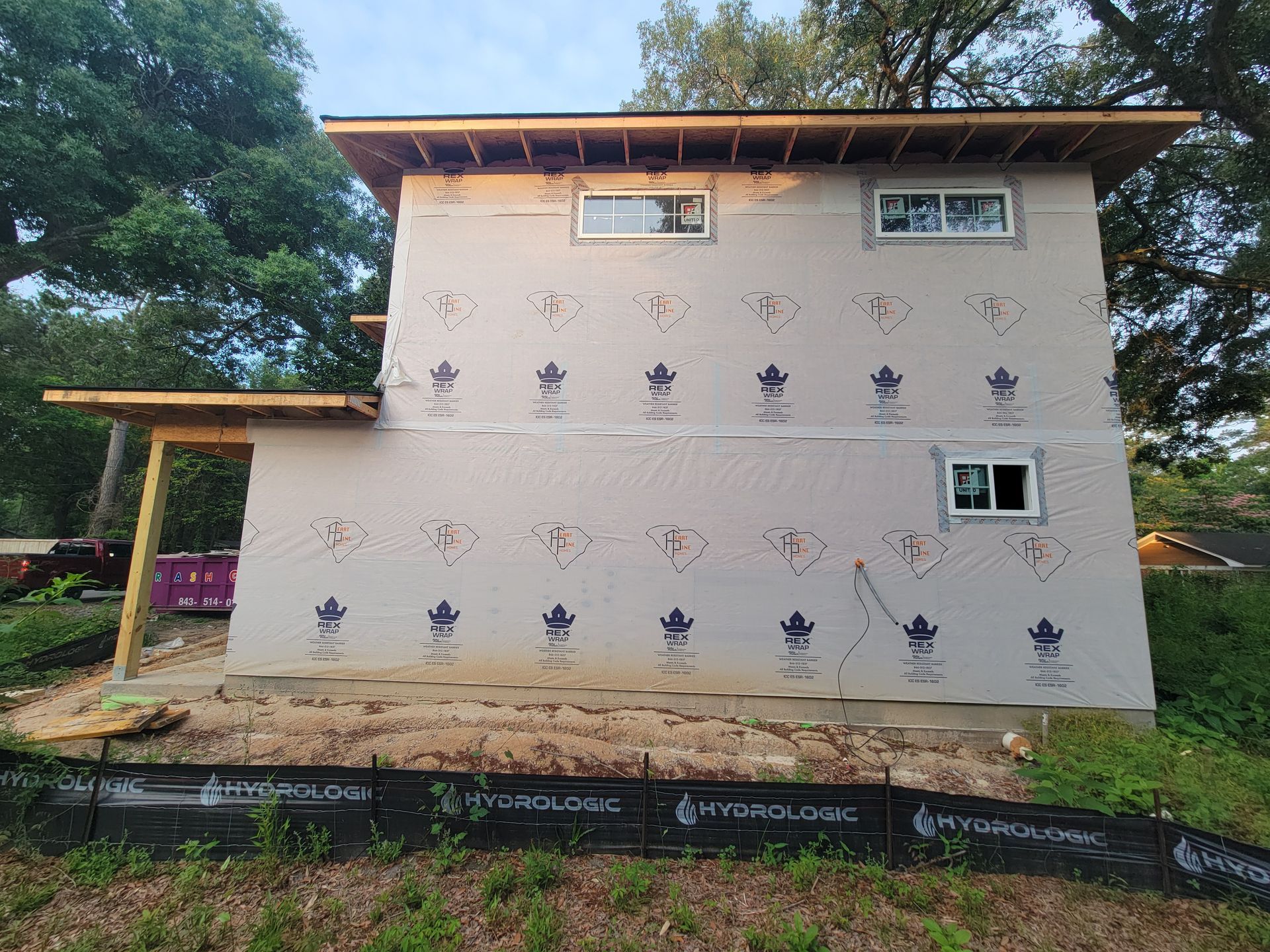 A house is being built on a hill with trees in the background.