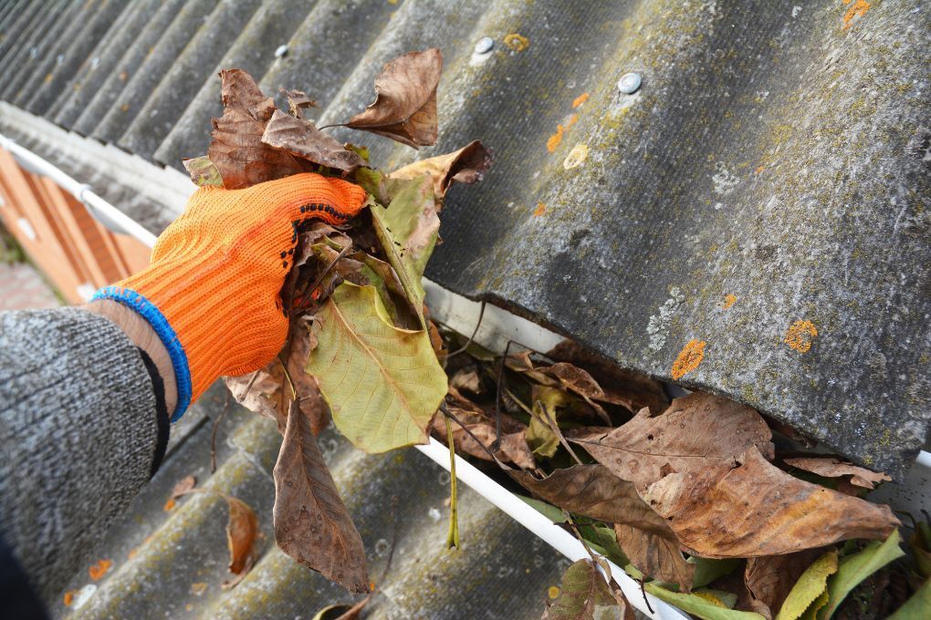 Roofers Kilmarnock hand clearing a gutter before cleaning