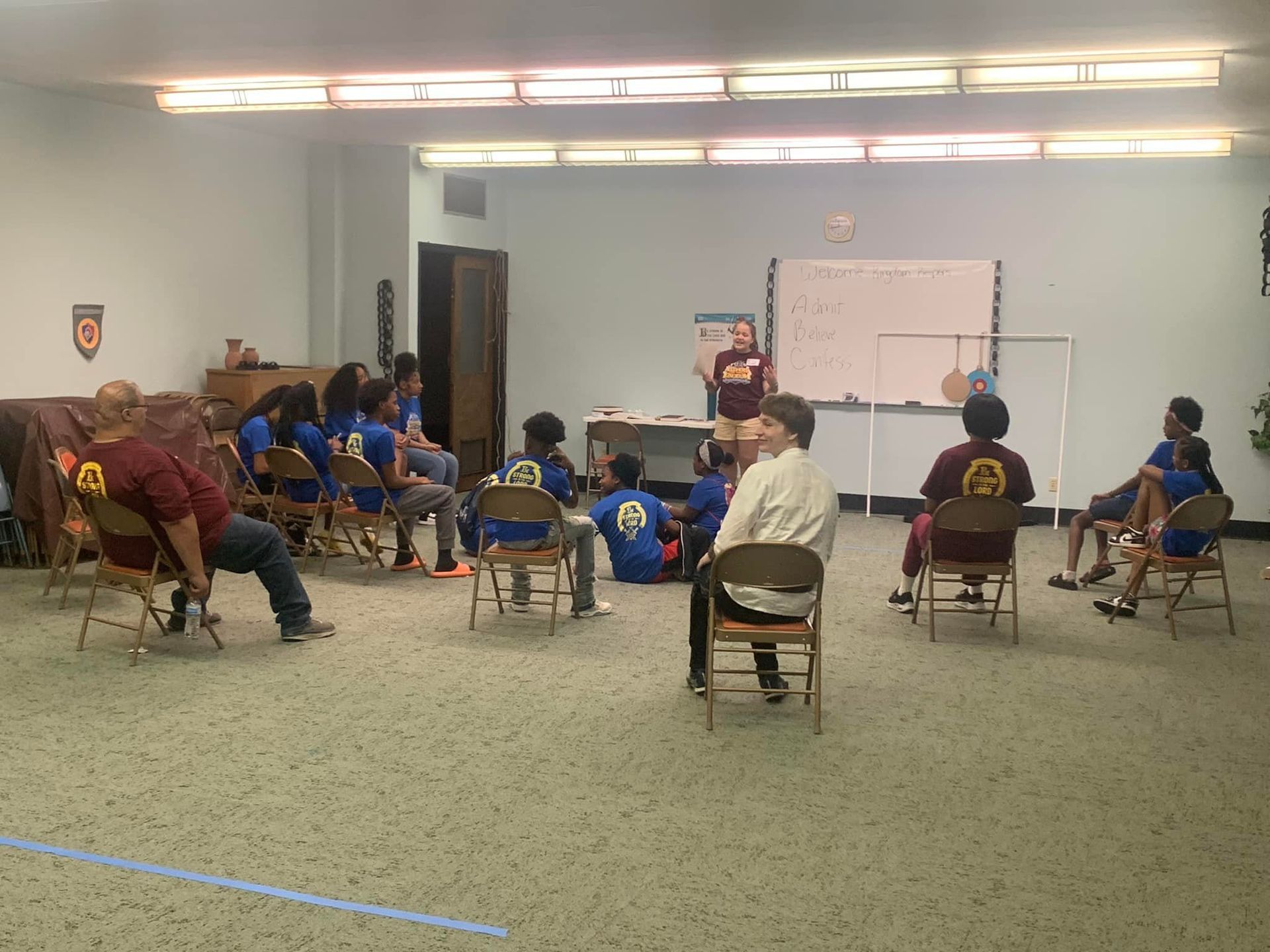 Children sit in a room listening to a gospel presentation