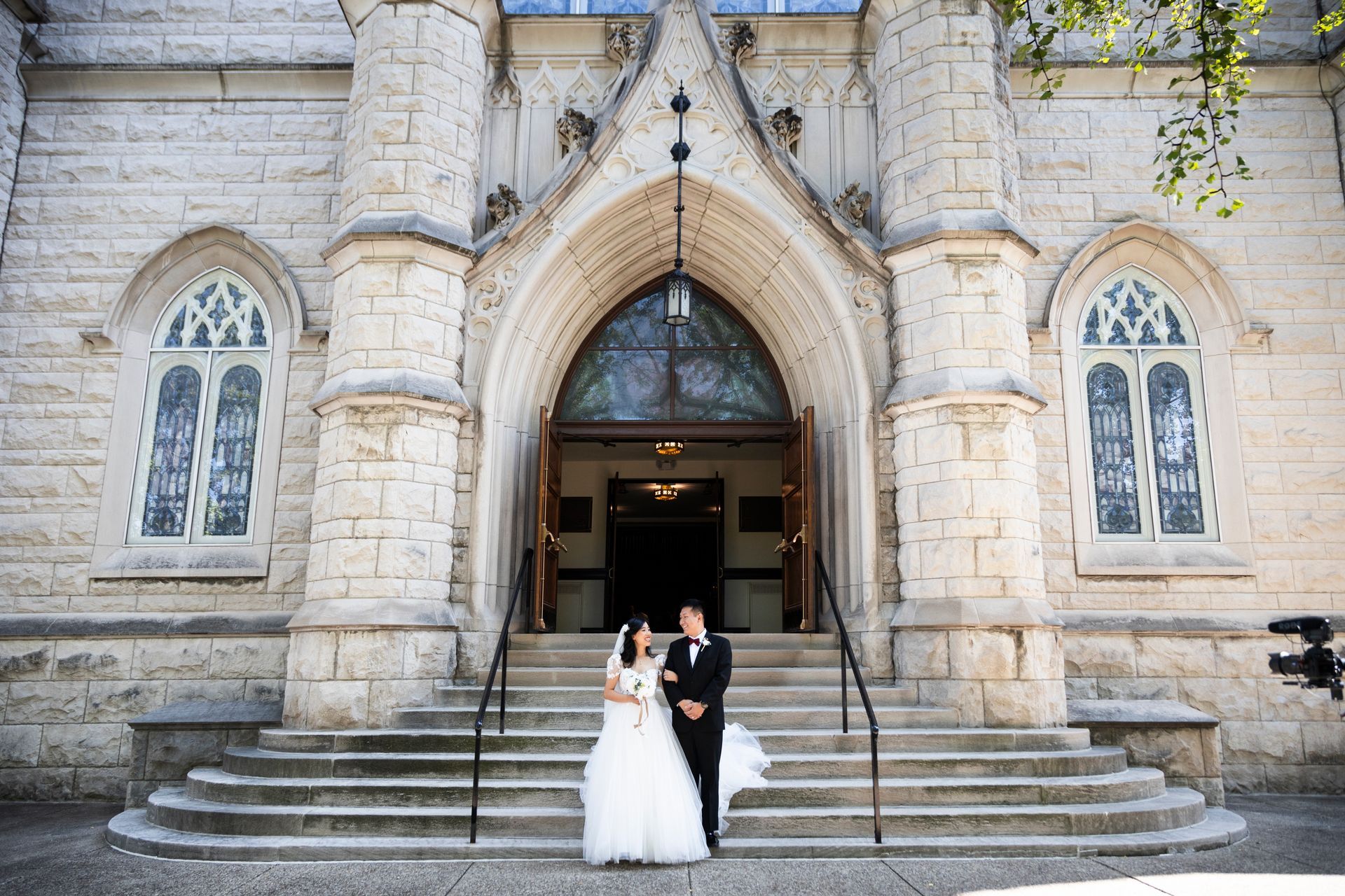 A happy couple celebrating their wedding outside Walnut Street Baptist Church.