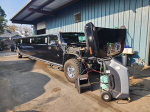 Black limousine with hood up for repairs parked outside | Tedious Auto Repair