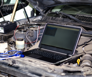 Laptop in use to diagnose vehicle with hood open | Tedious Auto Repair