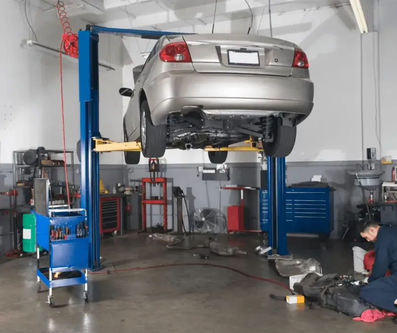 Gray car on lift in garage | Tedious Auto Repair
