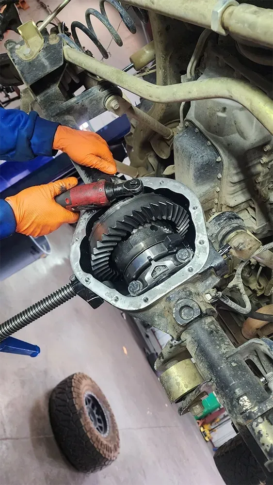 Underneath vehicle, technician performing repairs | Tedious Auto Repair