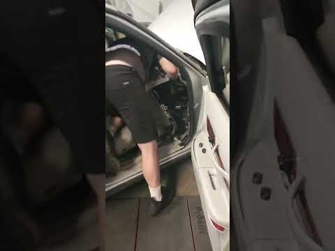 Technician performing repairs inside white car, passenger side door open | Tedious Auto Repair
