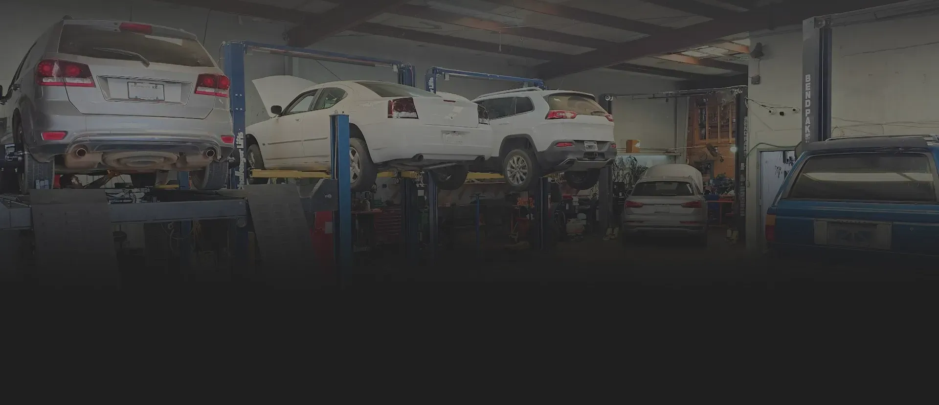 Vehicles on lifts in garage | Tedious Auto Repair
