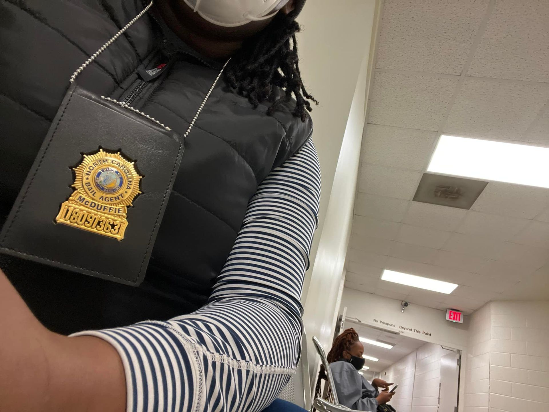 A woman wearing a mask and a badge around her neck.