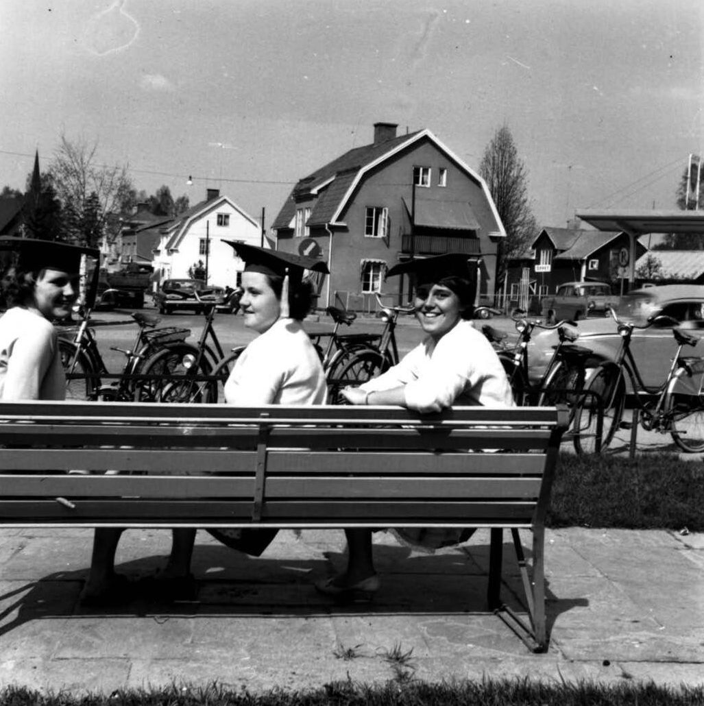 Ett svartvitt foto av två kvinnor som sitter på en bänk