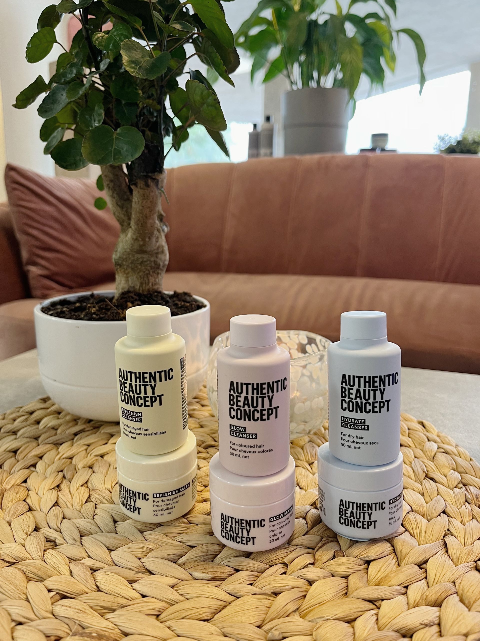 Tre flaskor med autentiskt skönhetskoncept staplas ovanpå varandra på ett bord.