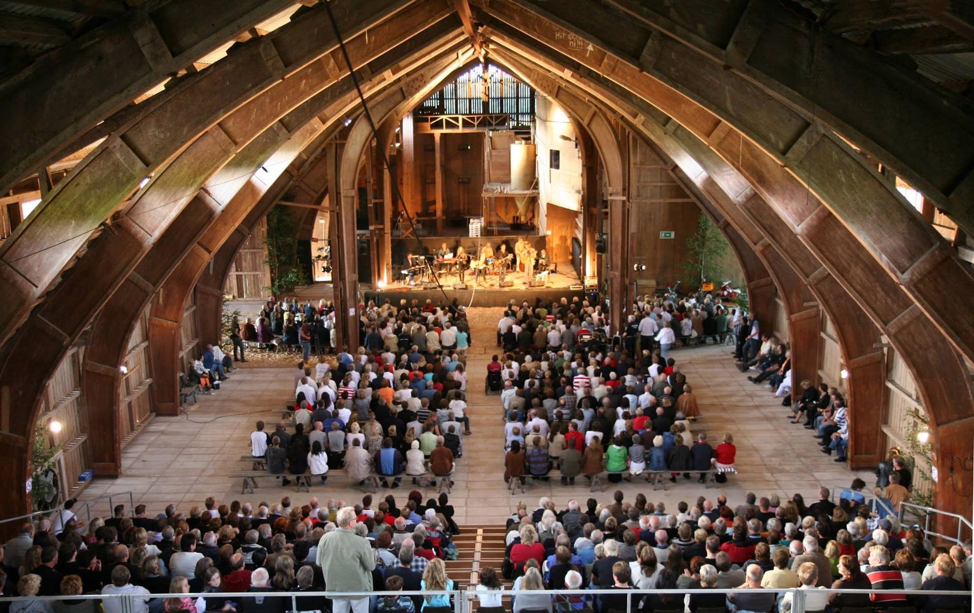 En stor grupp människor sitter i en kyrka och tittar på en konsert