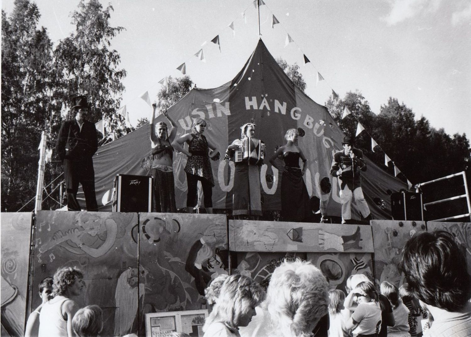 En grupp människor som står framför ett cirkustält