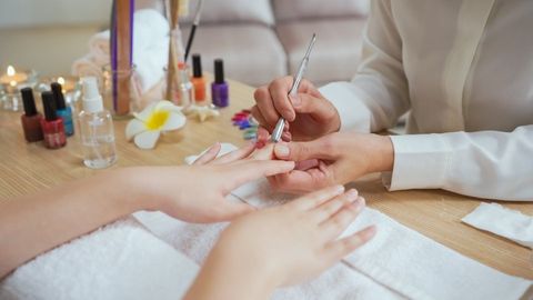 closeup of beautiful woman hands getting manicure in spa salon