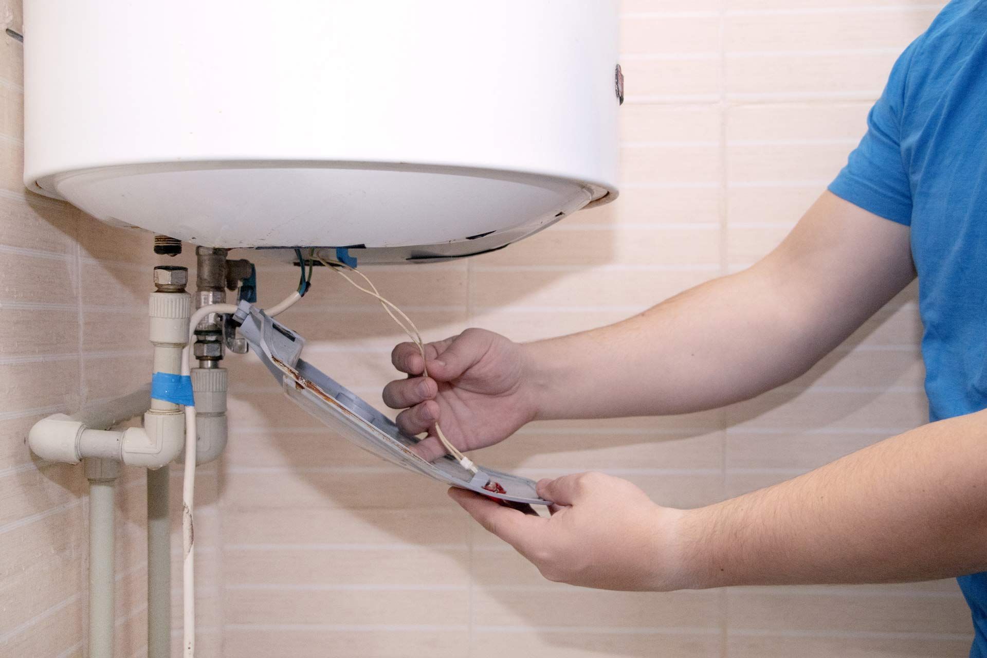 Person fixing a water heater. Person fixing a water heater.