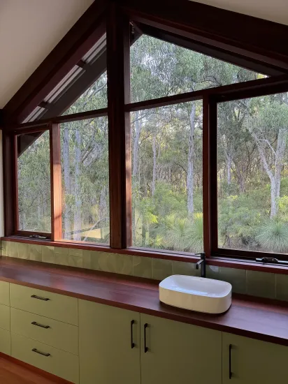 Wood-paneled sunroom with large windows, a built-in counter, and a white round container on the counter.