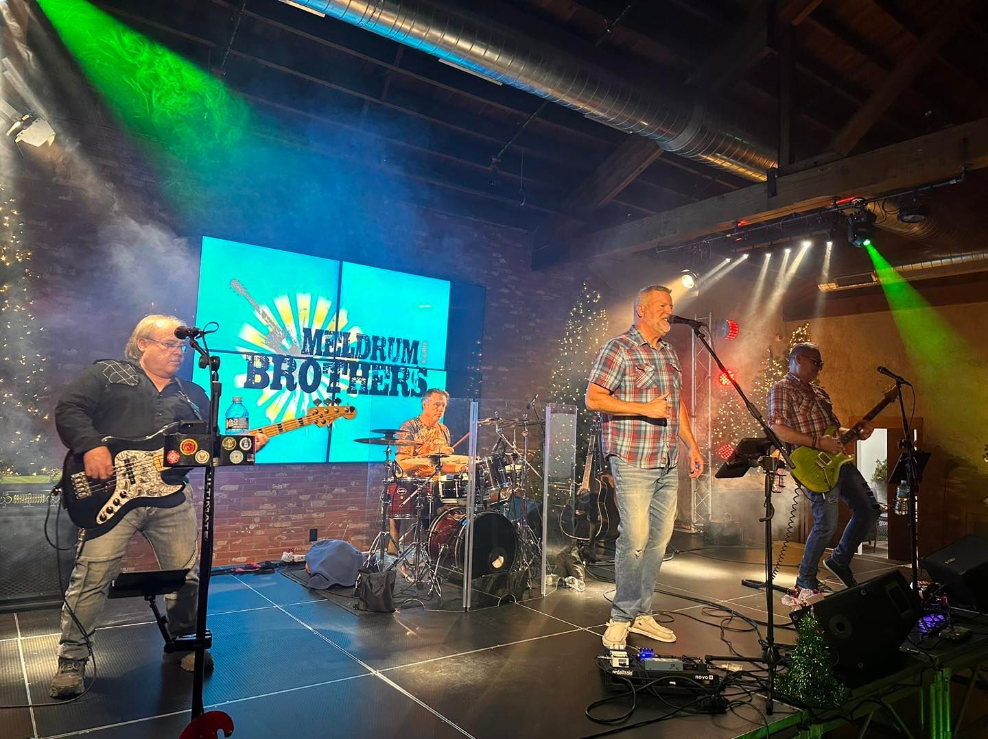 Meldrum Brothers are playing guitars and singing on a stage.