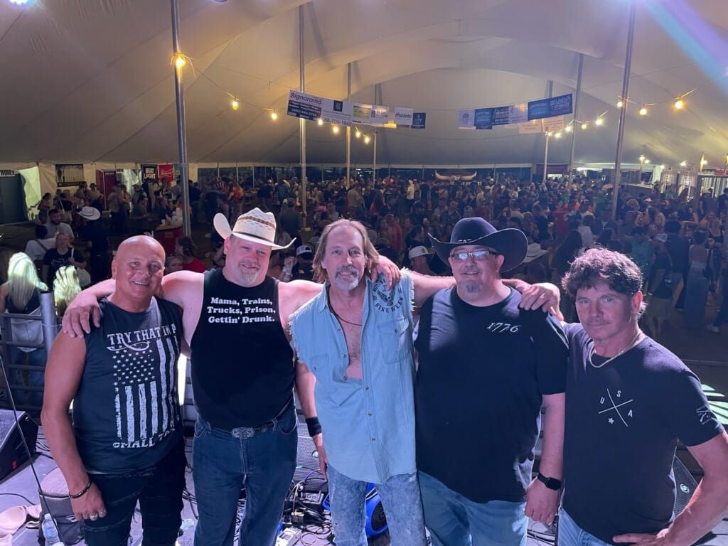 A group of men are posing for a picture in front of a crowd.