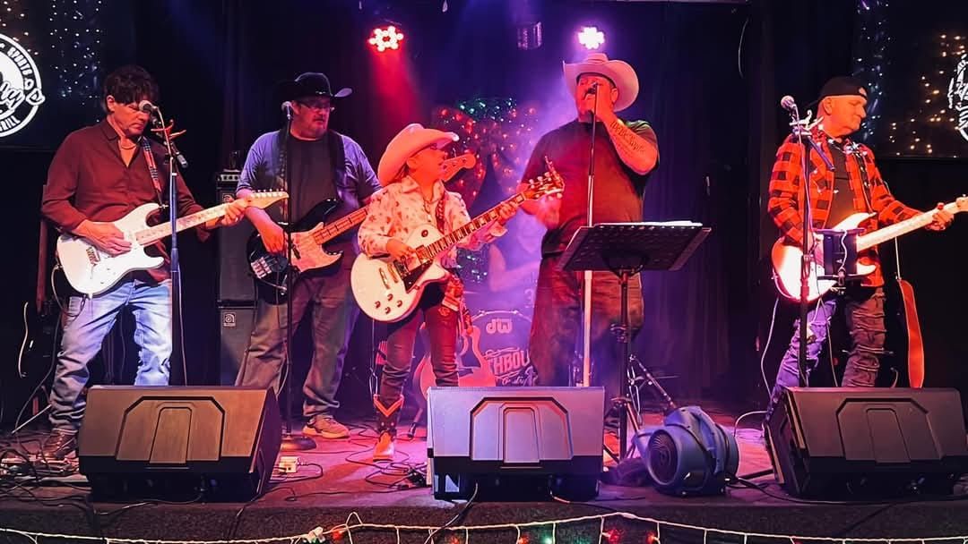 A group of men are playing guitars on a stage.