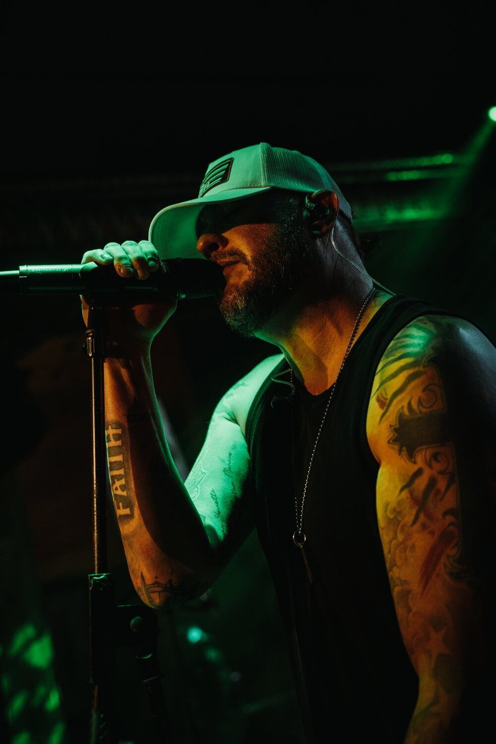 A man is singing into a microphone in a dark room.