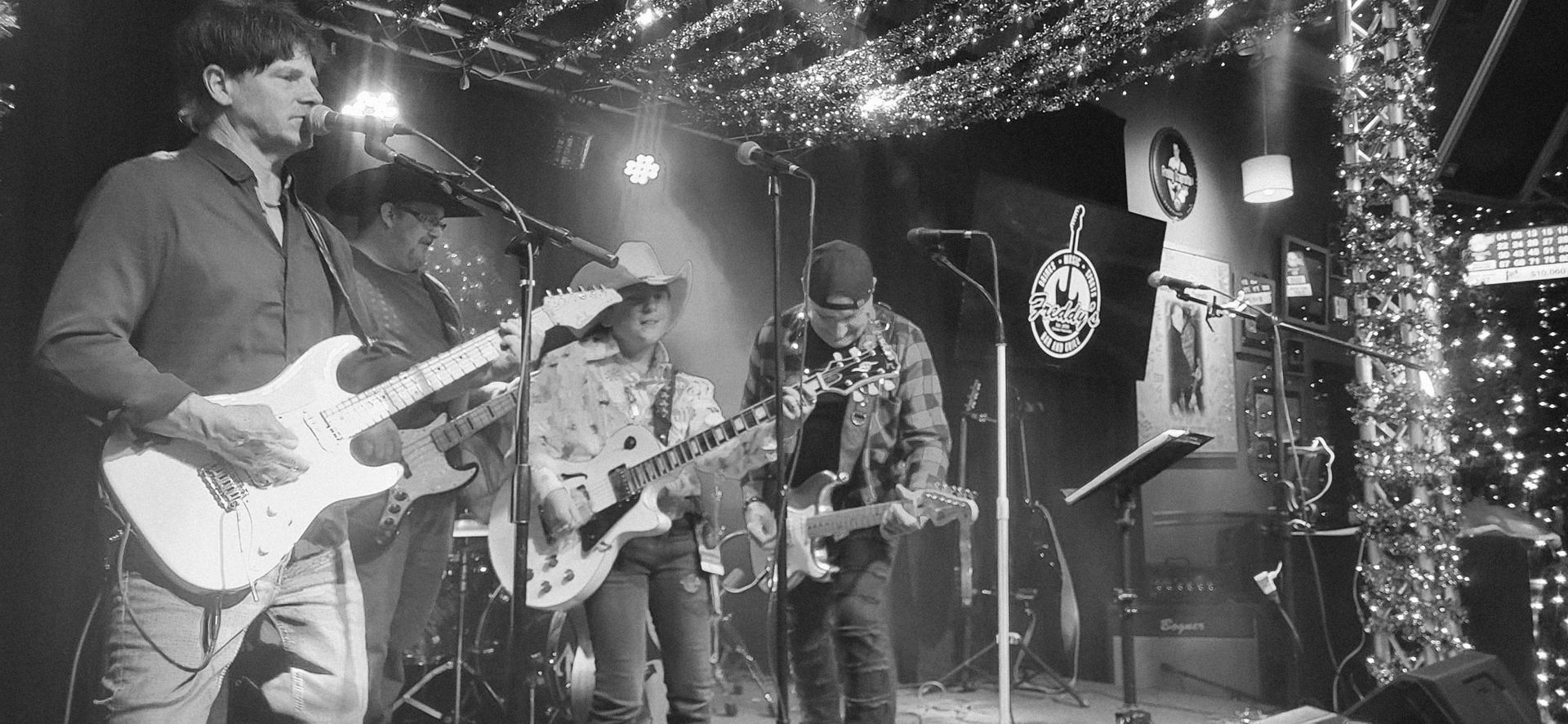 A black and white photo of Northbound band playing guitars on stage.