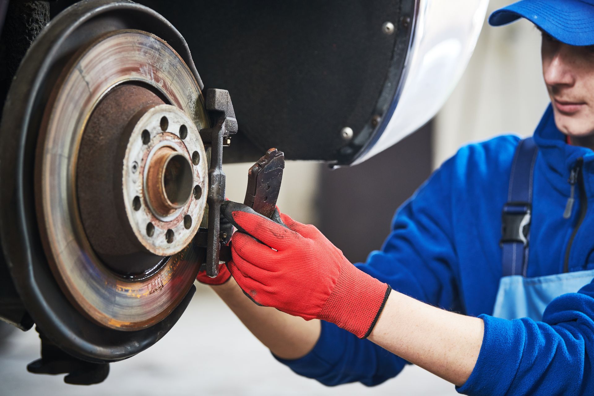 A man is fixing the brake pads on a car.